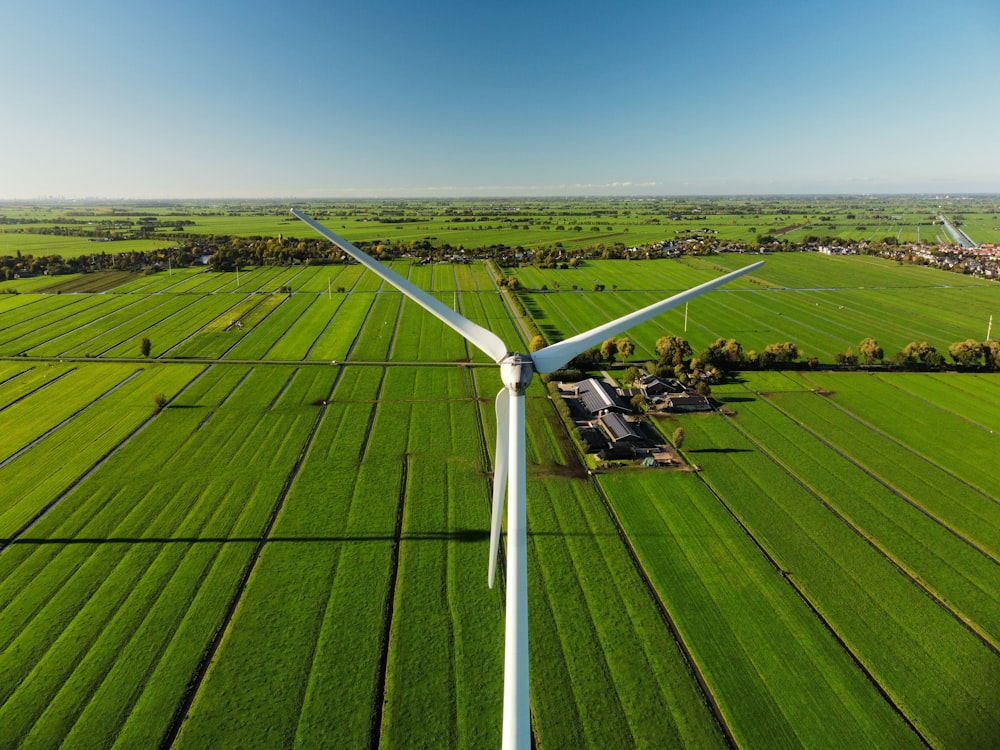 an aerial view of a wind turbine in a green field