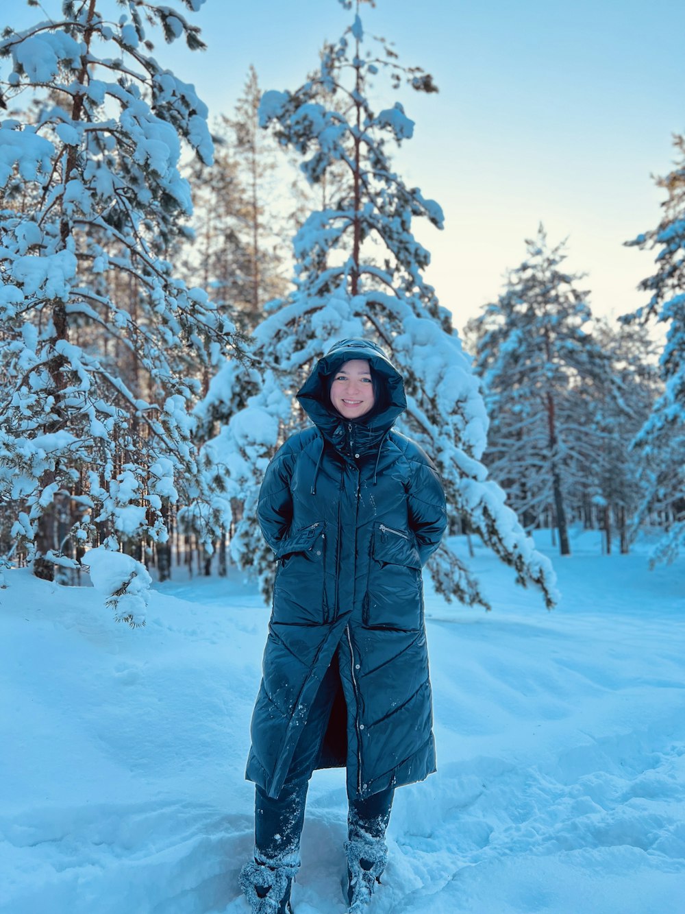 a person standing in the snow in front of trees