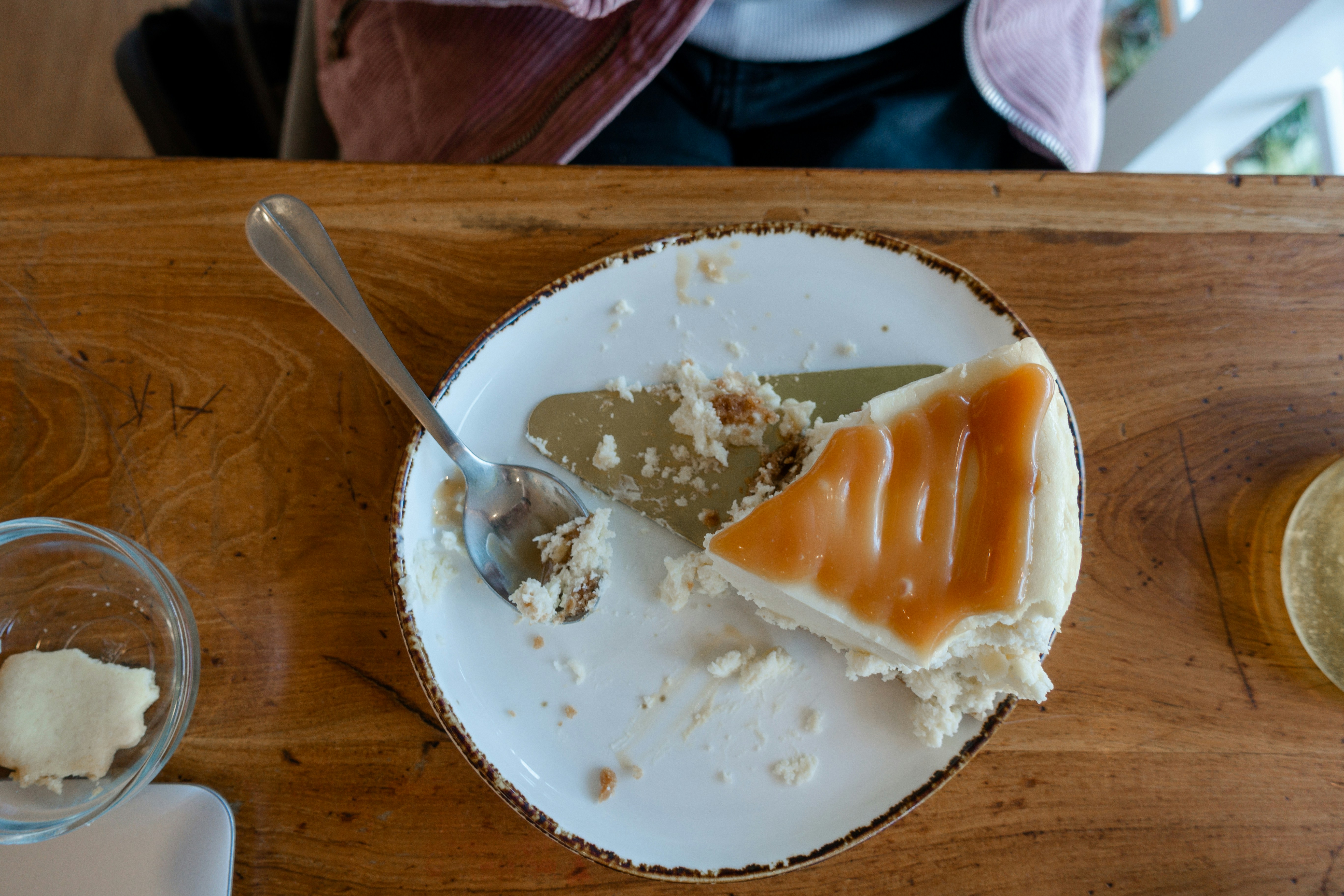 a white plate topped with a piece of cake next to a spoon, 