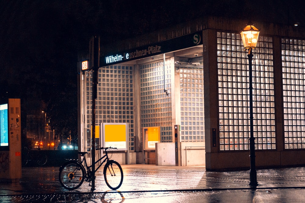 a bike parked in front of a building at night