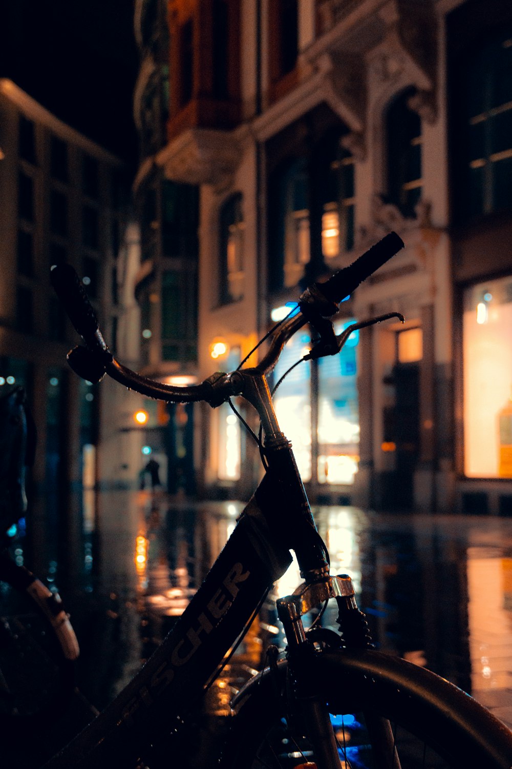 a bicycle parked in front of a building at night