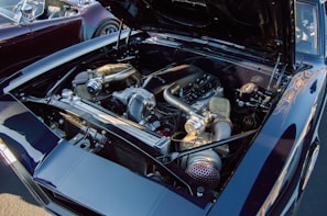 A high-performance car engine with exposed components such as large air intakes and shiny metallic parts. The engine bay is clean and well-organized, with a focus on showcasing the technical aspects of the engine.