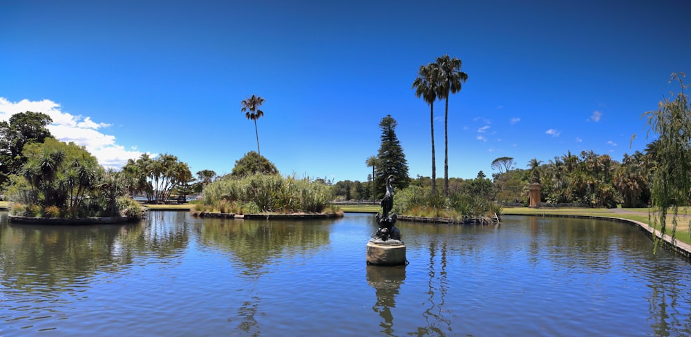 a small boat floating on top of a lake surrounded by palm trees