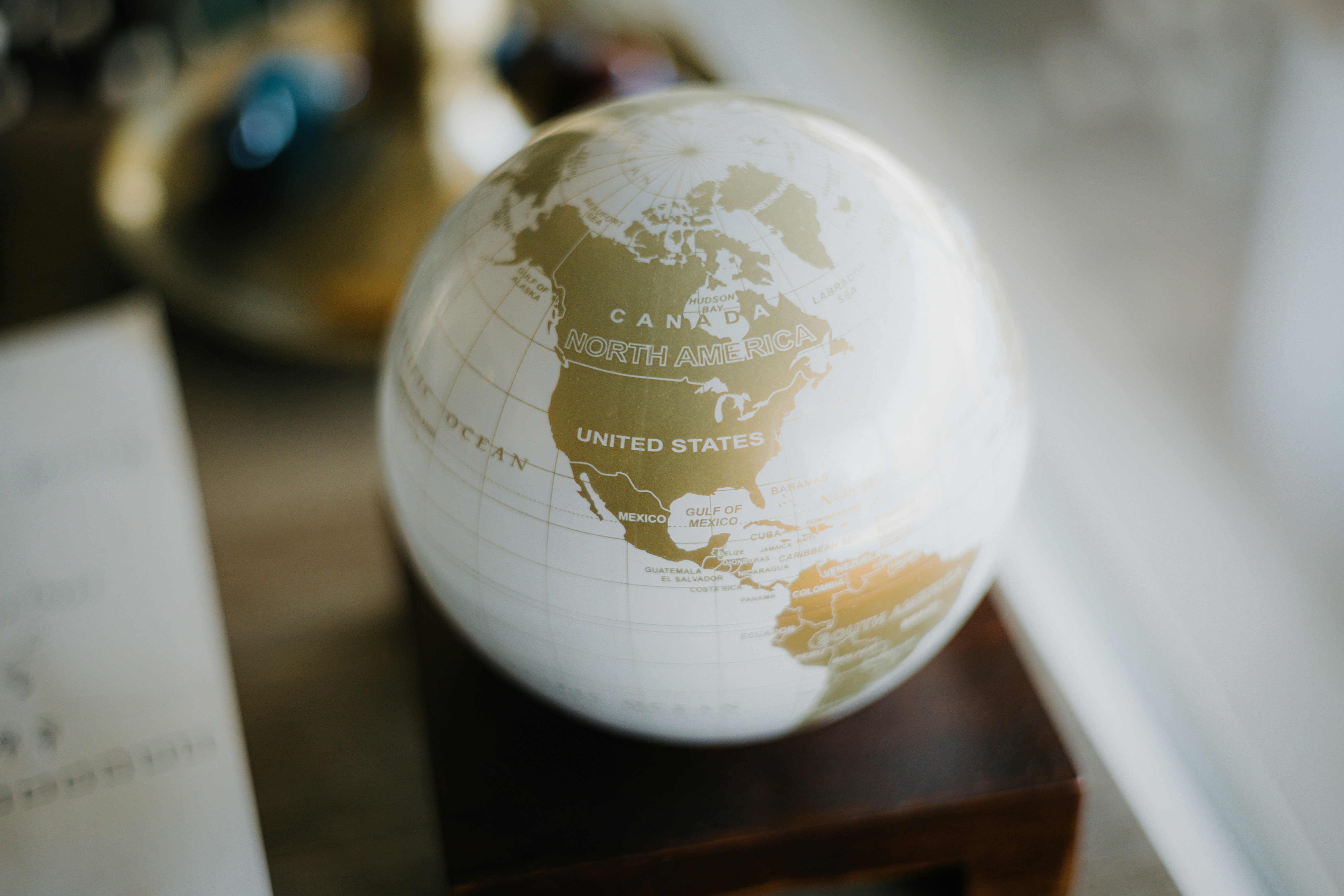 a white and gold globe sitting on top of a wooden stand