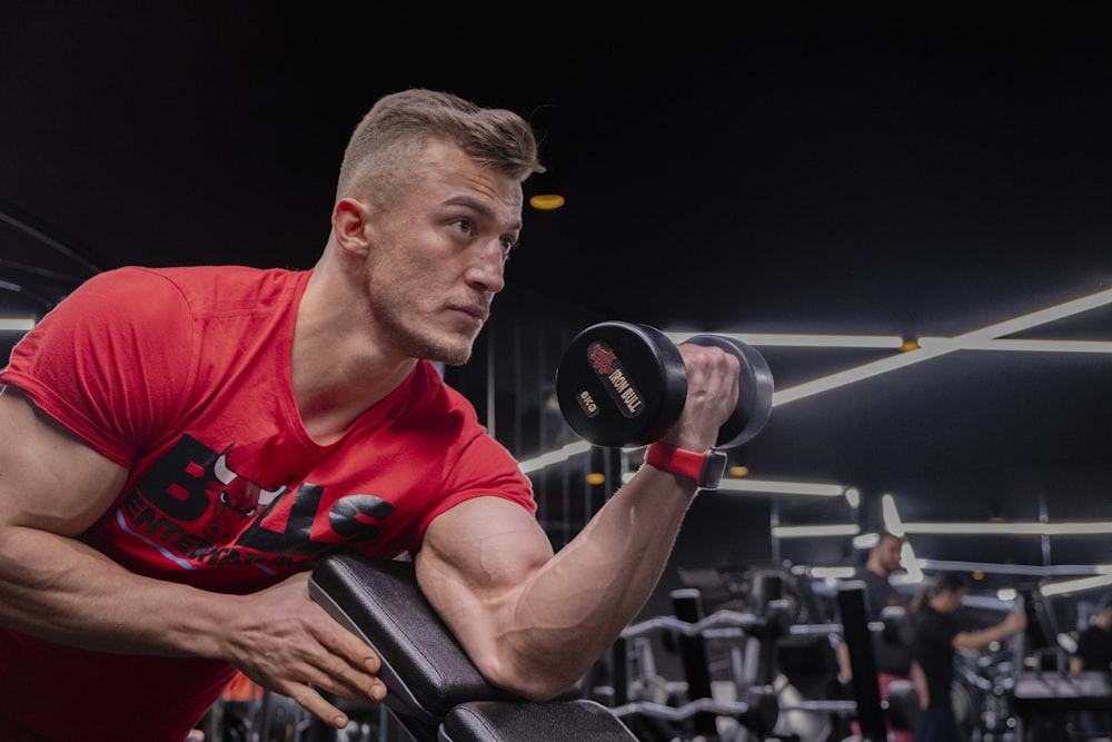 a man in a gym holding a dumbbell