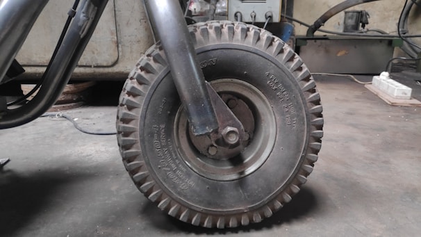 Close-up of a tyre being repaired with tools on a workbench in a garage.