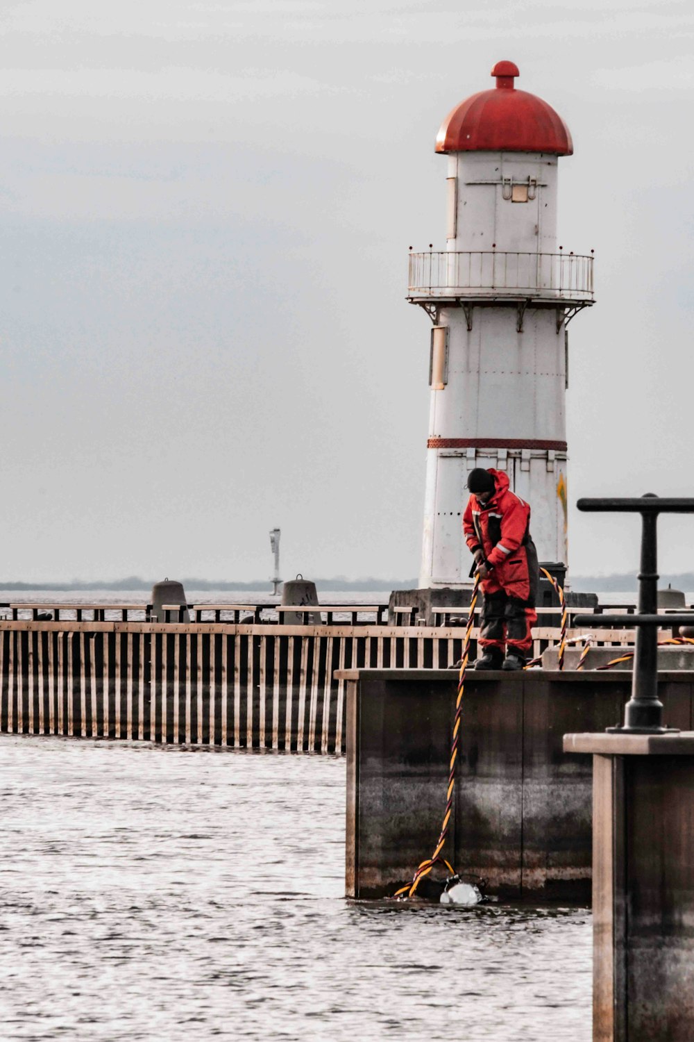 a man standing on a dock next to a light house