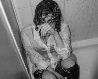 a person sitting in a bathtub covered in water