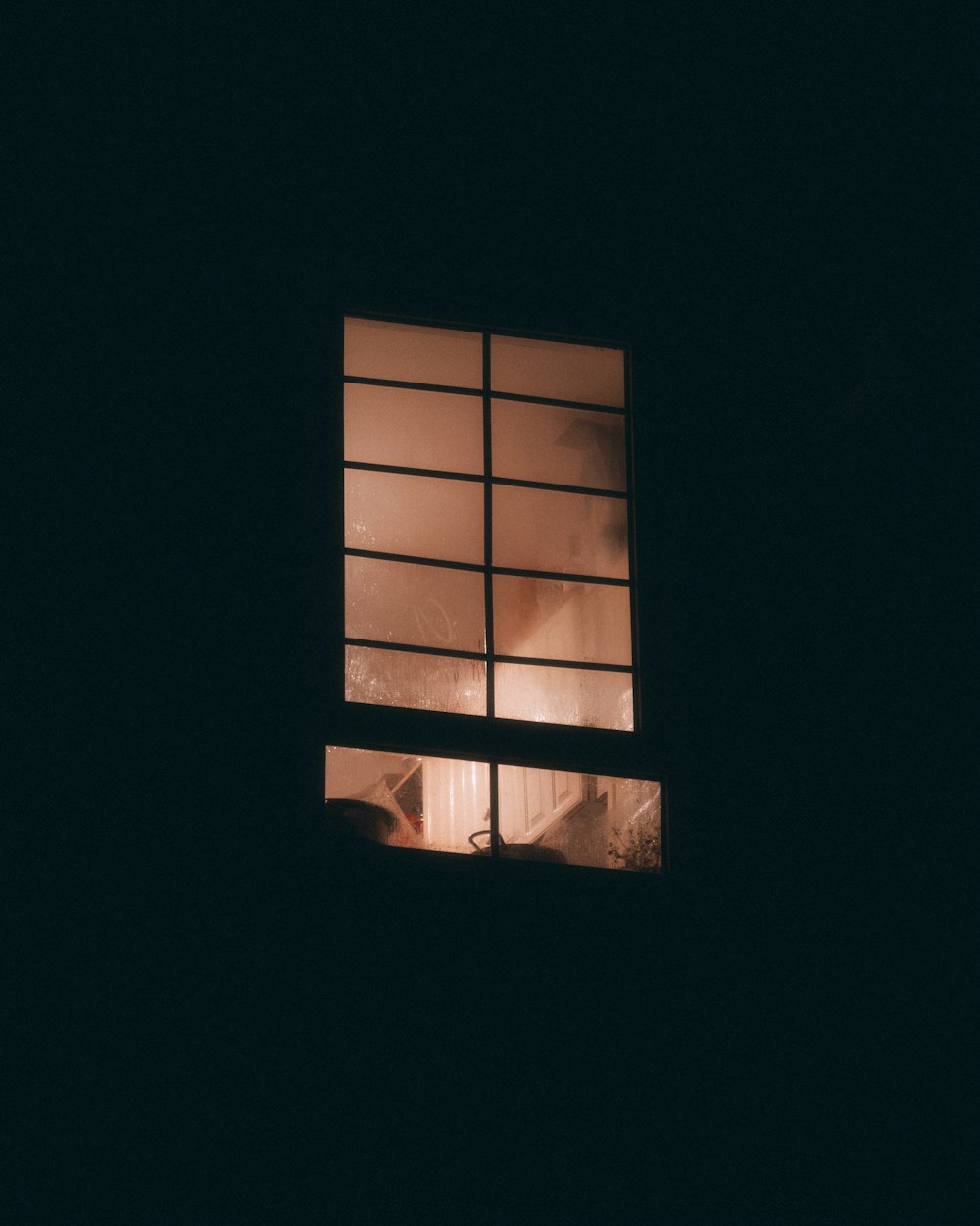 a window with a view of a building in the dark