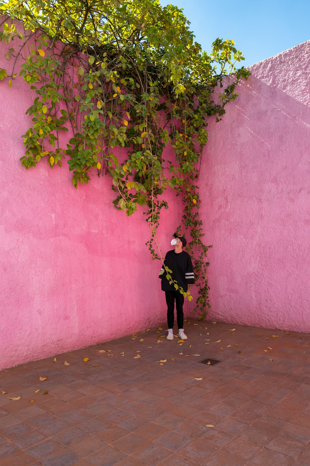 Une femme debout devant un mur rose