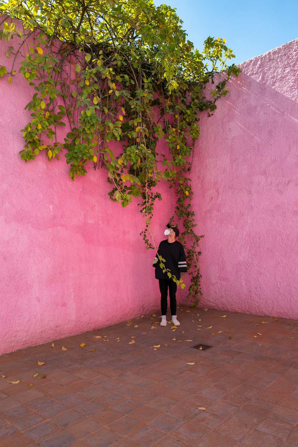 a woman standing in front of a pink wall