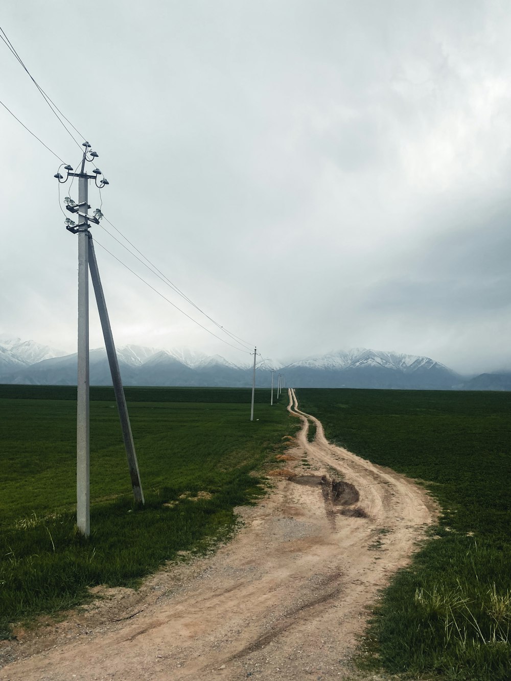 a dirt road going through a green field