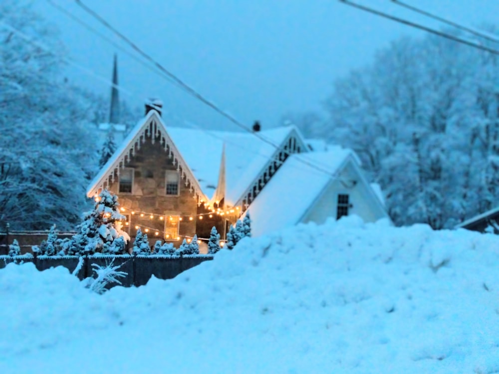 a house covered in snow with christmas lights