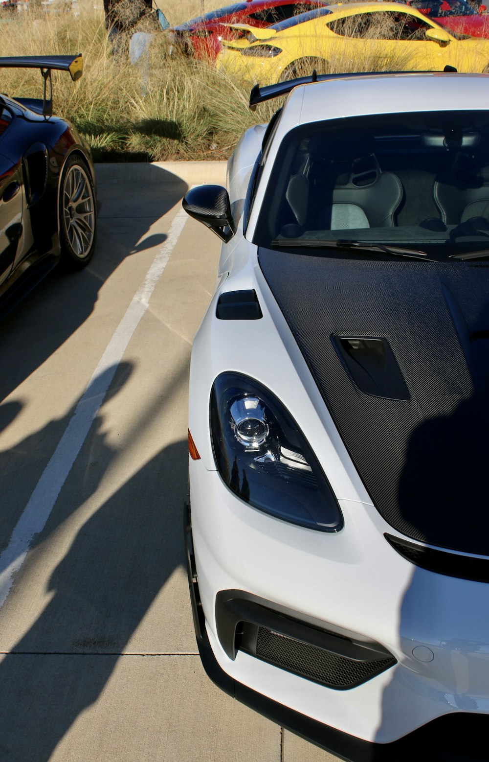 a white sports car parked next to a black sports car