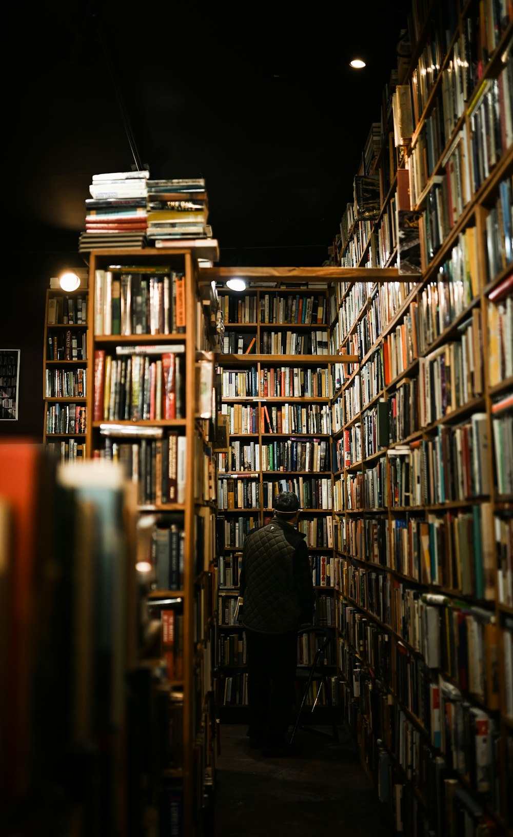 Eine Person, die in einem Raum voller Bücher sitzt