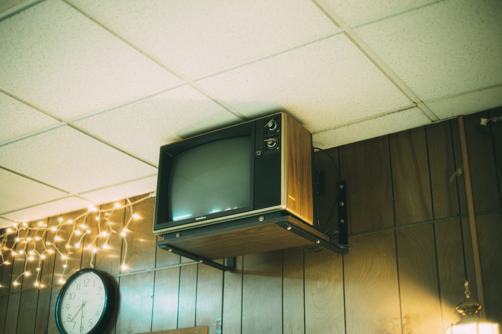 a television sitting on top of a wooden shelf