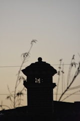 A Stars Chimney Sweeps technician cleaning a residential chimney at dusk.