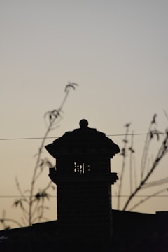 A Stars Chimney Sweeps technician cleaning a residential chimney at dusk.