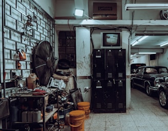 a garage filled with lots of junk and old cars