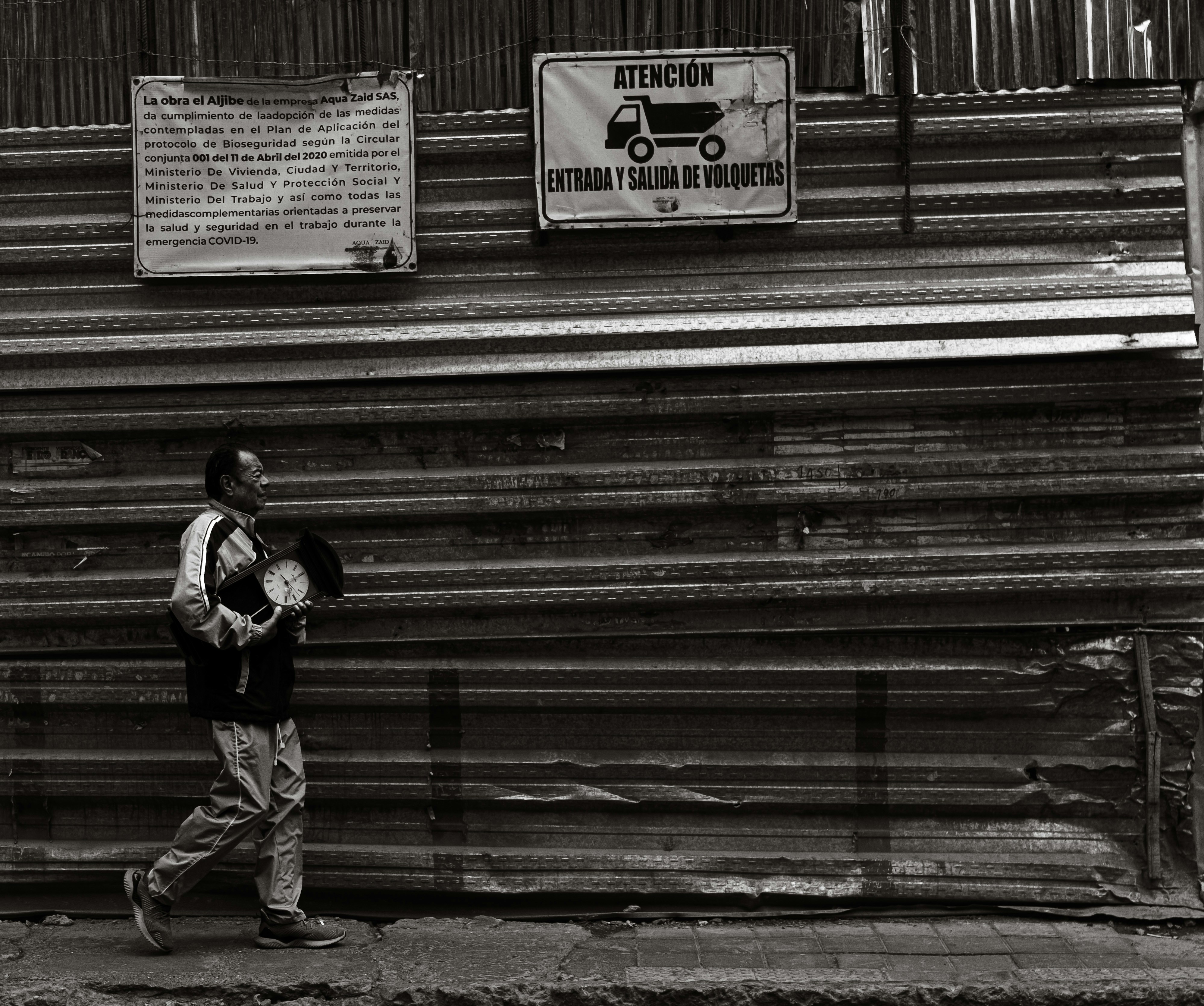 a black and white photo of a man walking down the street