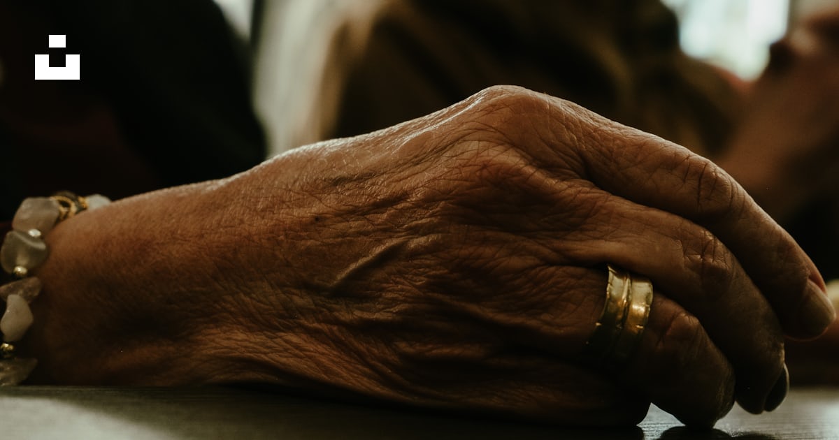A close up of a person's hands resting on a table photo – Free Hand ...