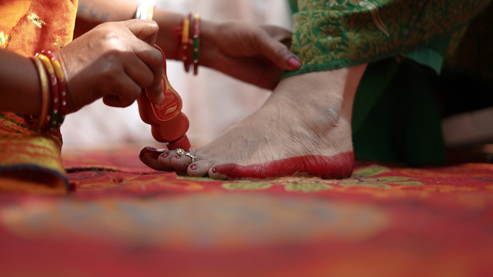 a woman is putting a candle on her foot