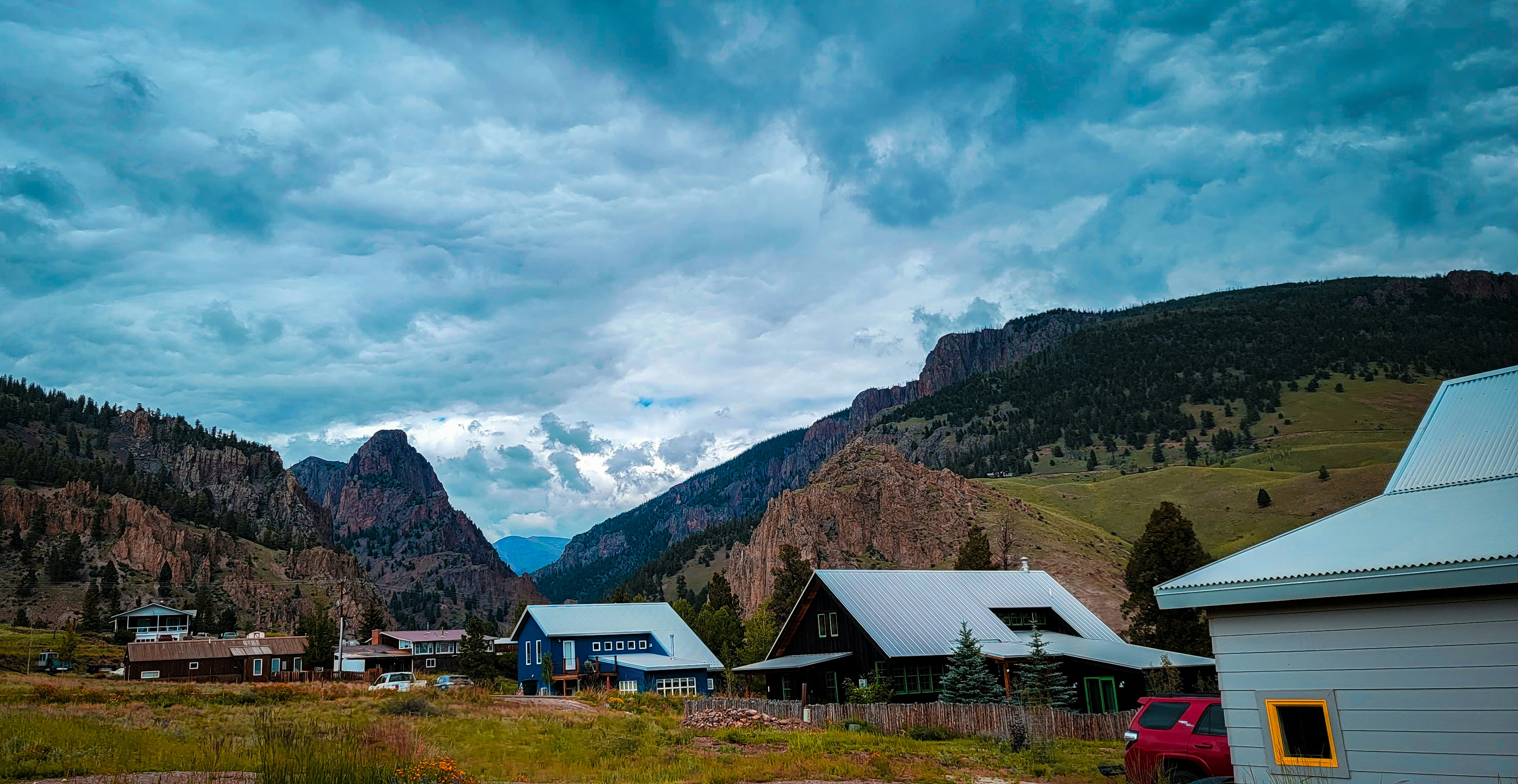 a group of houses sitting on top of a lush green hillside
