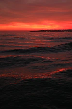 A vibrant sunset over the Pacific Ocean with radio waves symbolizing broadcast signals.