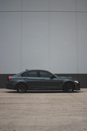 A sleek modern car with perfectly tinted windows parked outside a dealership.