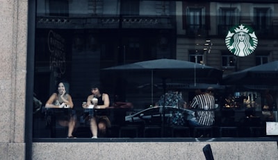 Customers enjoying coffee inside while their cars get a wash outside the window.