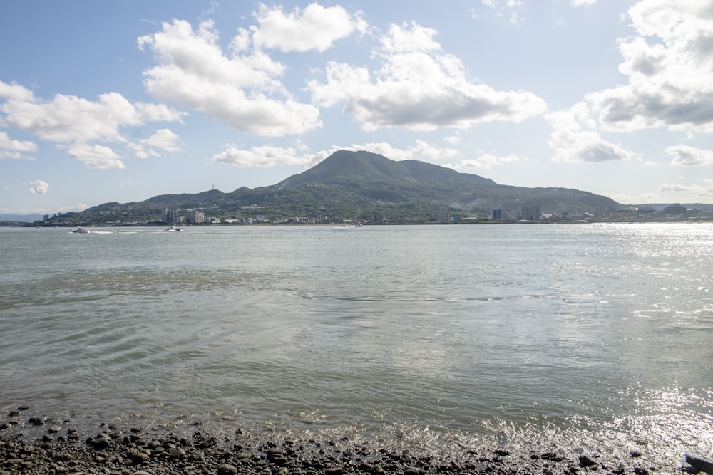 a body of water with a mountain in the background