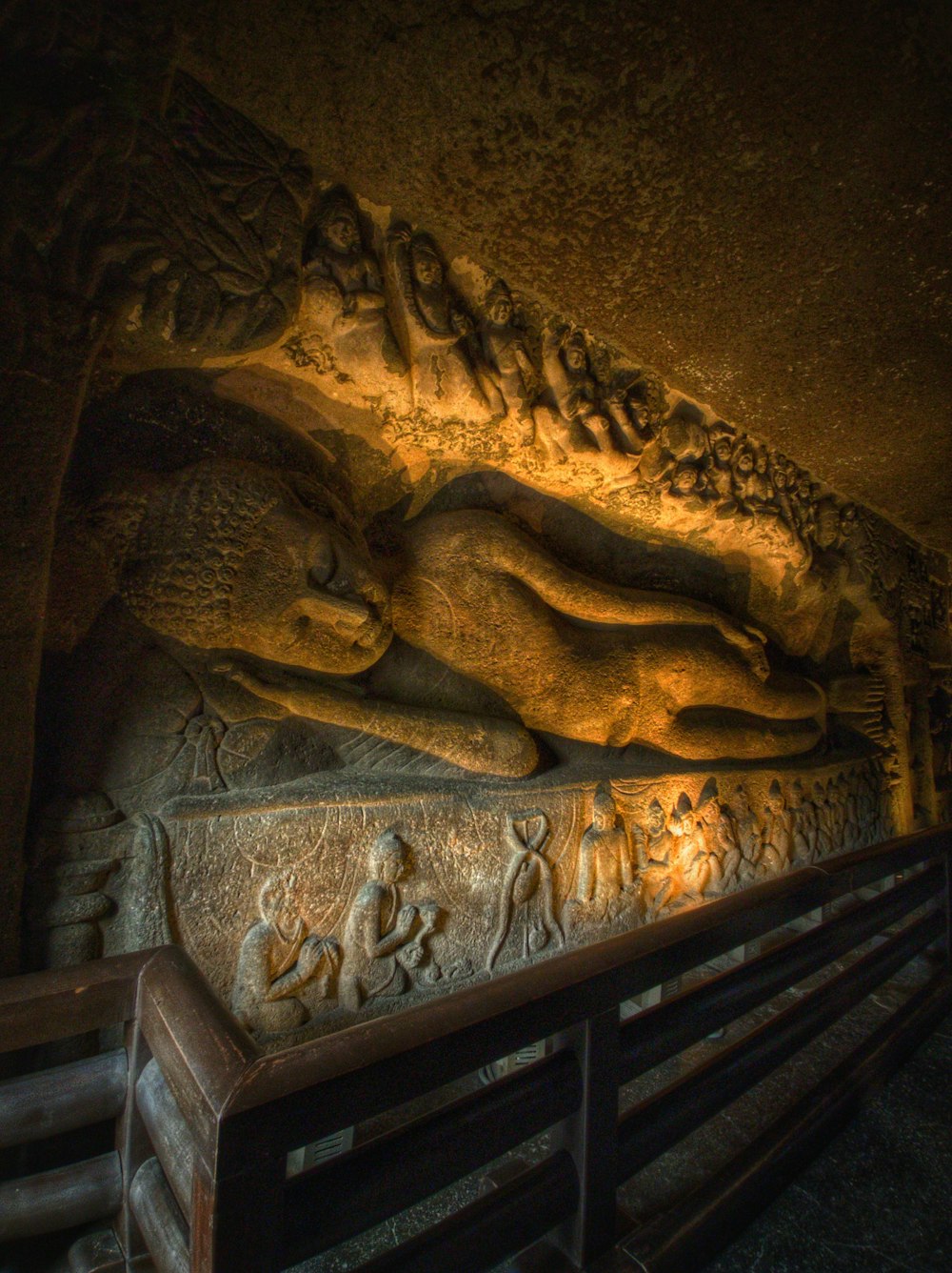 a statue of a person laying down on a bench