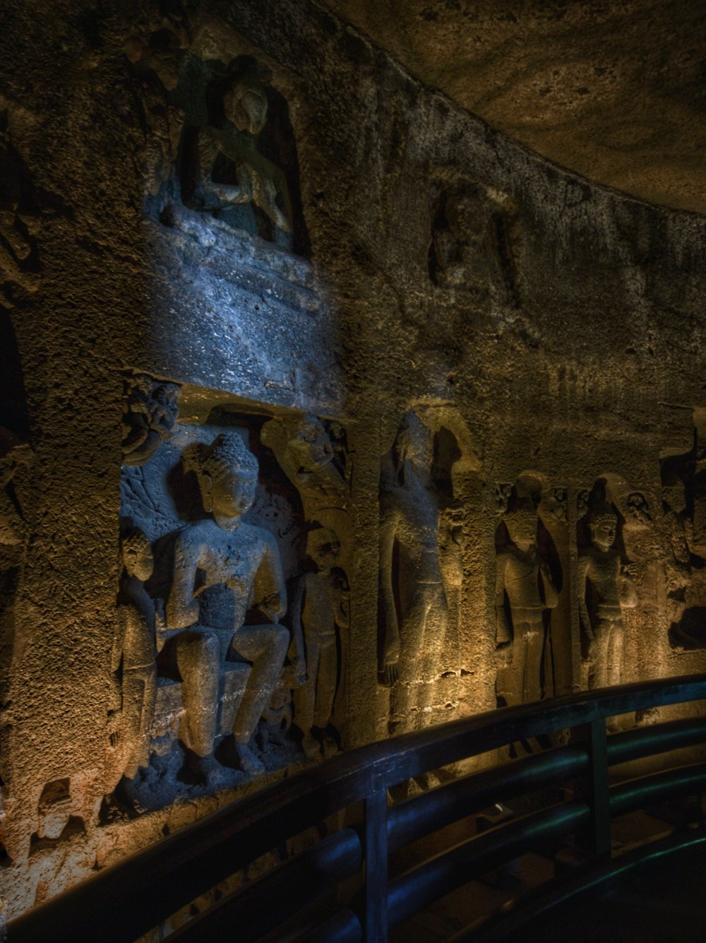 a stone wall with statues on it at night
