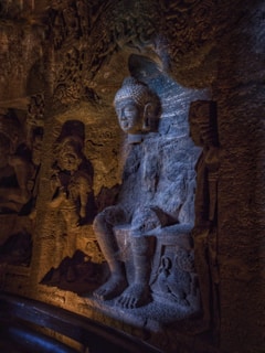 a statue of a seated man in a cave