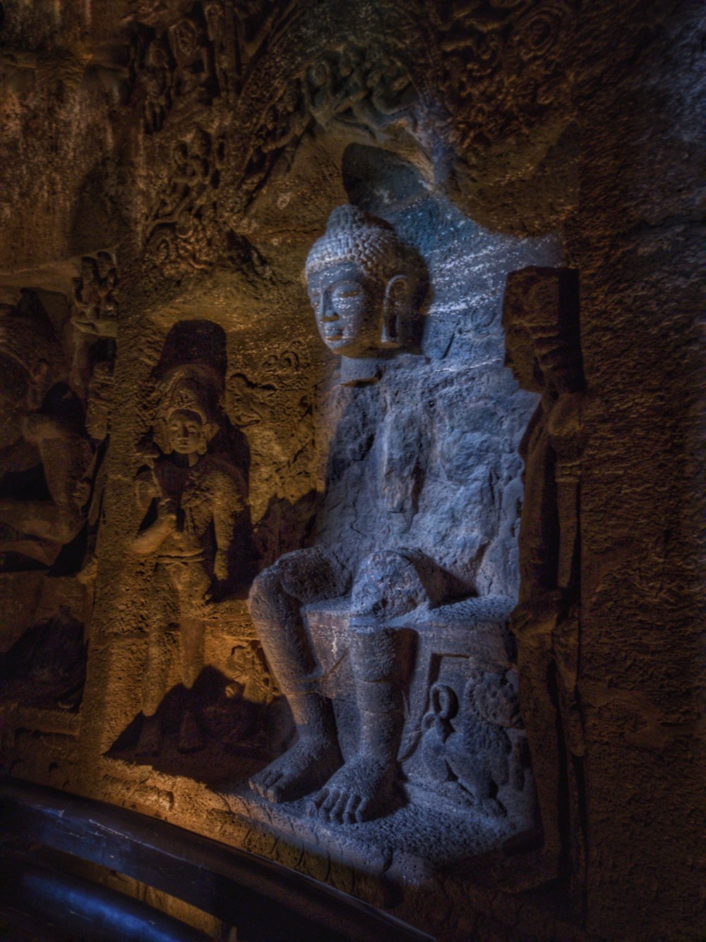 a statue of a seated man in a cave