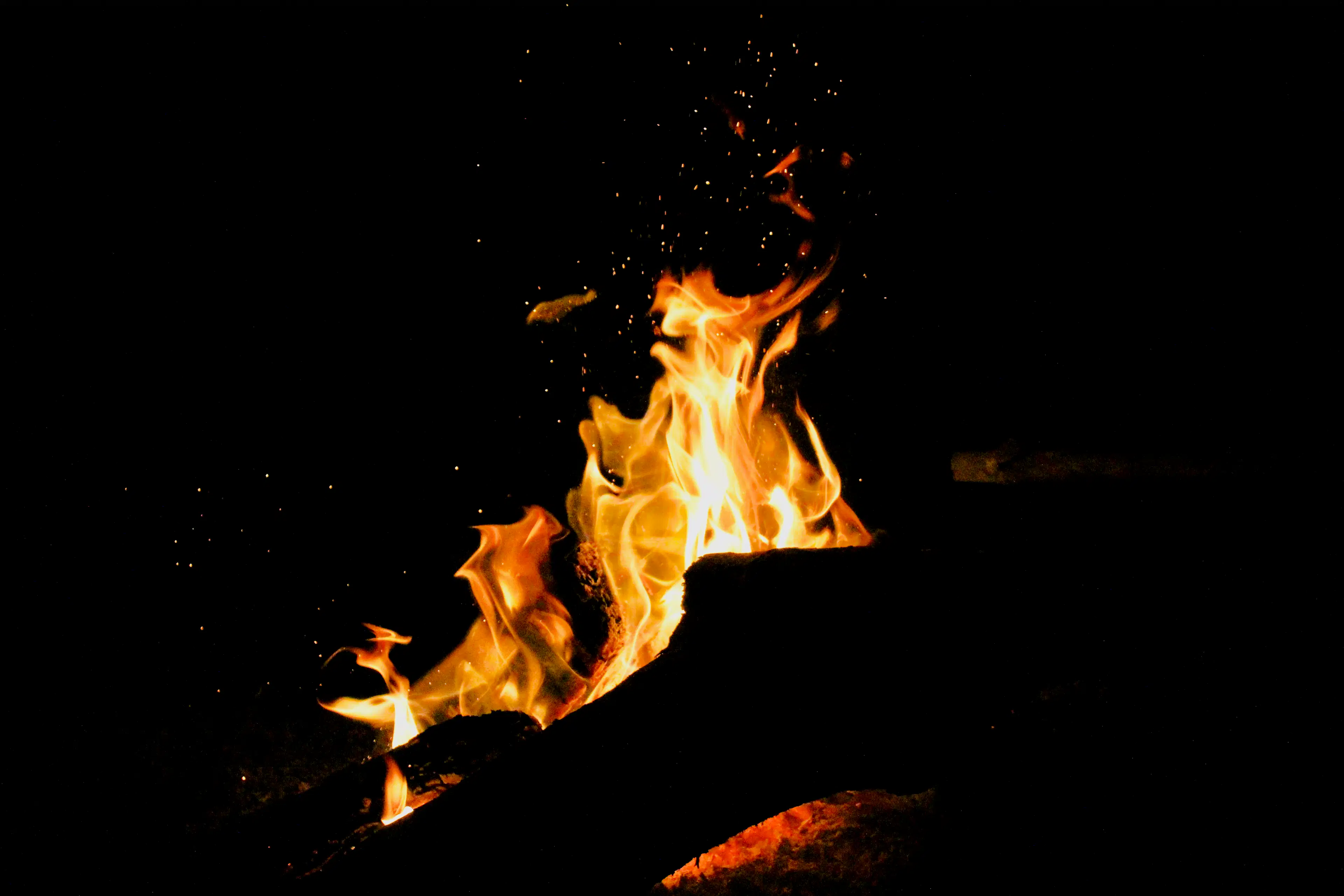 A small campfire glowing against the dark night