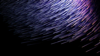 A vibrant burst of electric violet light streaking across a deep charcoal background, symbolizing creative energy.