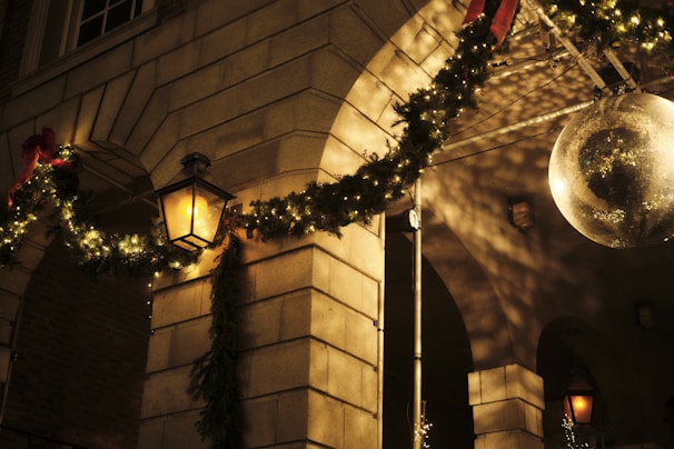 A close-up of a balloon arch in red, green, and white framing a Christmas party entrance.