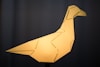 a yellow origami bird sitting on top of a table