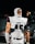 A football player is wearing a white uniform with the number 45 and the word 'PREP' on the chest area. The player is equipped with protective gear and has eye black under the eyes. The background is out of focus, possibly a stadium setting at night.