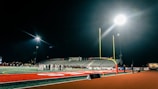 Goalpost glistening under stadium lights with yellow end zone markings shining bright.