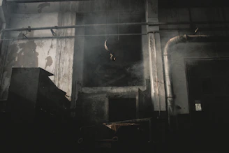 An old factory floor with rows of machinery under soft, dusty light.