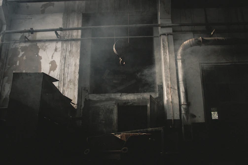 An old factory floor with rows of machinery under soft, dusty light.