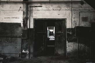 a dark room with a door open and a car parked in the doorway