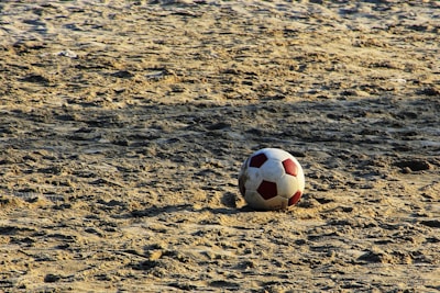 A close-up of a futevôlei ball on the sand.