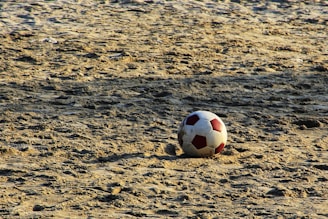 A close-up of a futevôlei ball on the sand.
