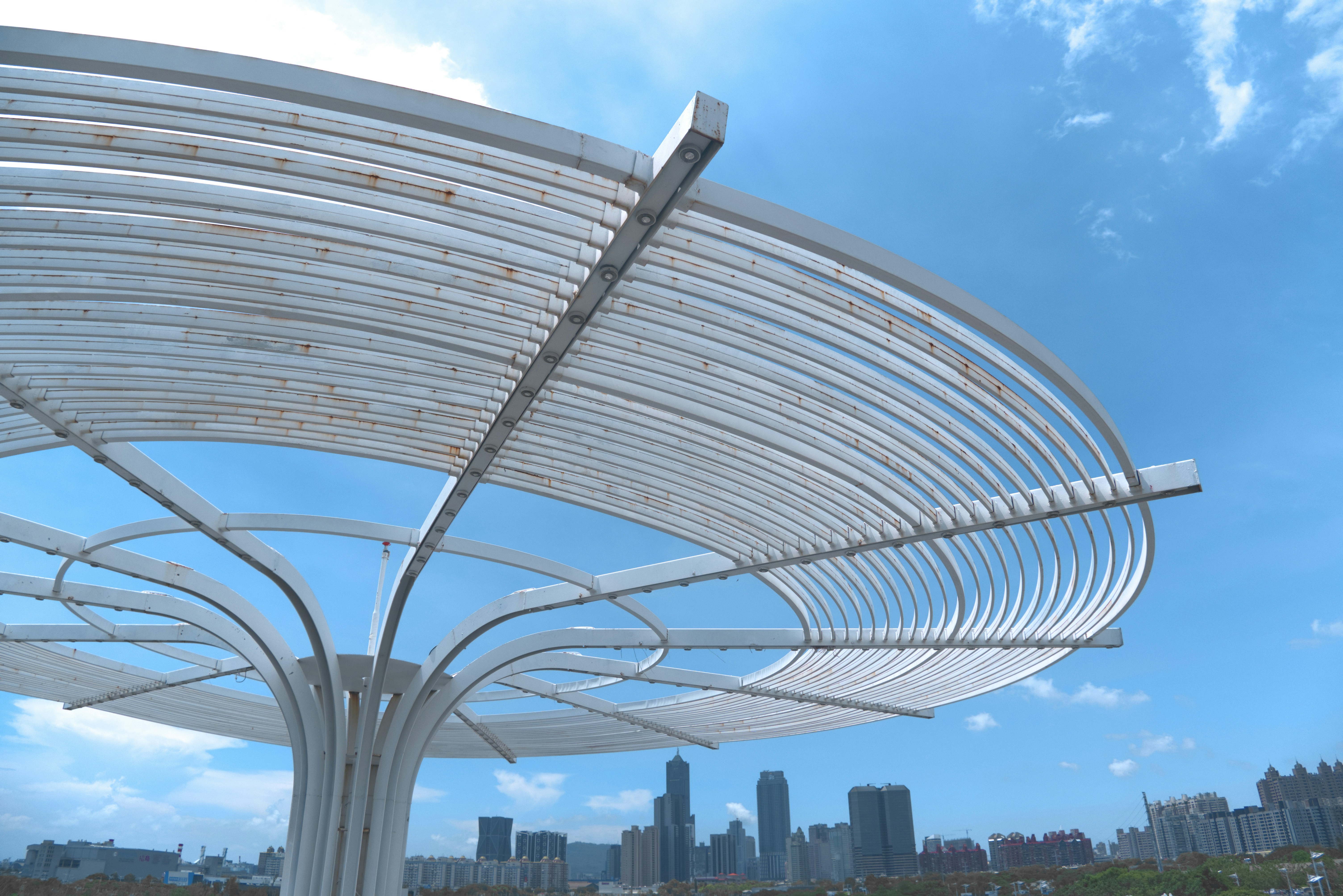 a large metal structure with a city in the background