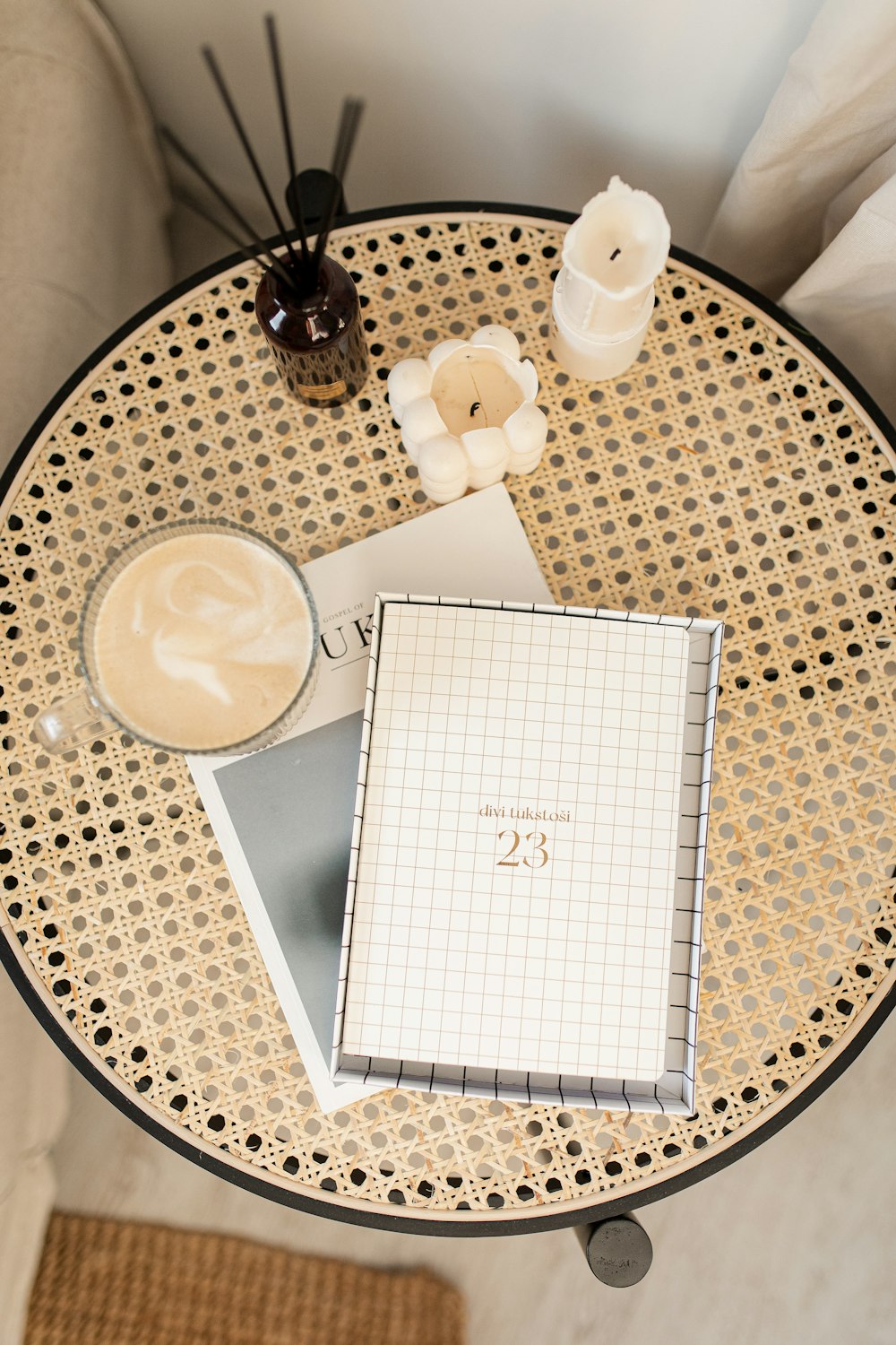 a coffee table with a notebook, candle, and candles on it