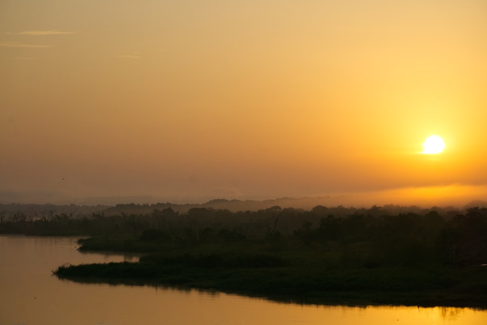 the sun is setting over a body of water