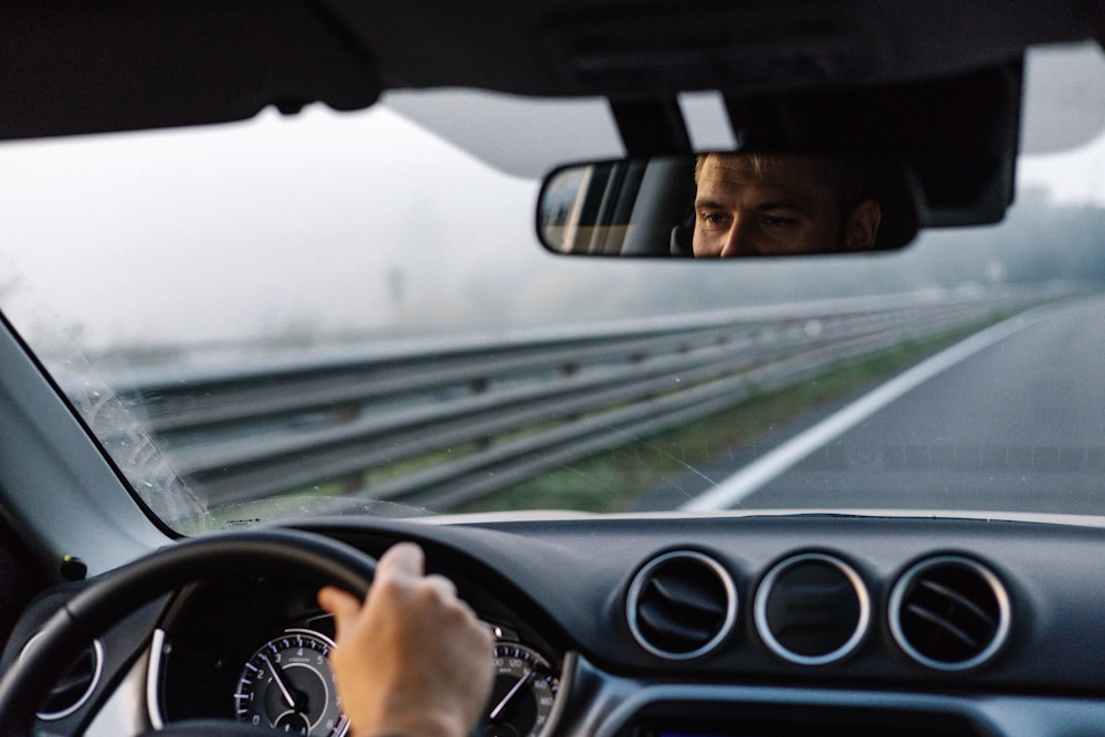 Un hombre conduciendo un automóvil en una carretera